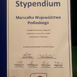 Zbliżenie na otwartą teczkę z dyplomem Stypendium Marszałka Województwa Podlaskiego